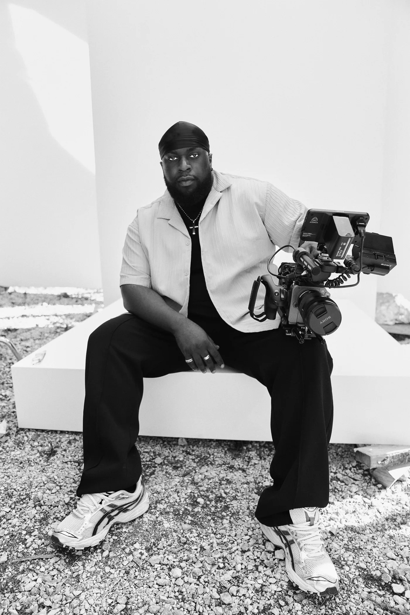 Emmanuel Whajah seated beside a film camera